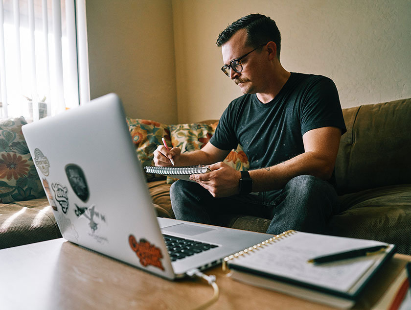 Junger Mann mit Laptop im Home Office